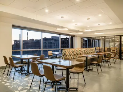 a restaurant with tables and chairs and large windows at Homewood Suites By Hilton Toledo Downtown in Toledo