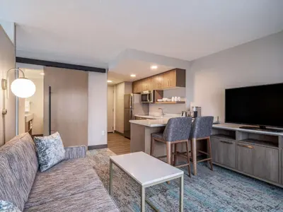 a living room with a couch and a kitchen at Homewood Suites By Hilton Toledo Downtown in Toledo
