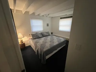 a bedroom with a bed and two windows at Rock Stalls Lodge in Logan