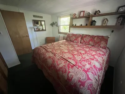 a bedroom with a bed with a red comforter at Rock Stalls Lodge in Logan
