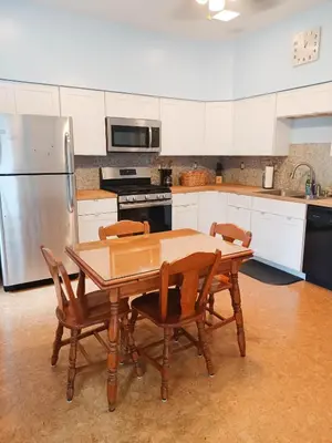 a kitchen with a wooden table with chairs and a refrigerator at Huge 2 Bedroom House in the Heart of Northside! in Cincinnati