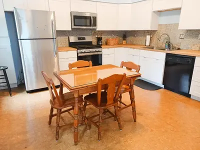 a kitchen with a wooden table with chairs and a refrigerator at Huge 2 Bedroom House in the Heart of Northside! in Cincinnati