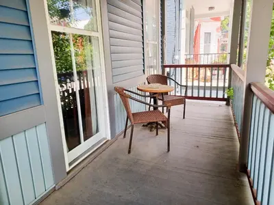 a porch with two chairs and a table on it at Huge 2 Bedroom House in the Heart of Northside! in Cincinnati