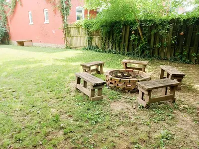 three picnic tables and a fire pit in a yard at Huge 2 Bedroom House in the Heart of Northside! in Cincinnati