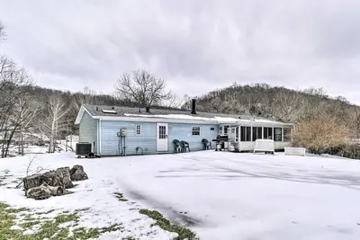 a blue house with snow on the ground at Rustic Family Home and Acreage about 20 Mi Hocking Hills in Lancaster