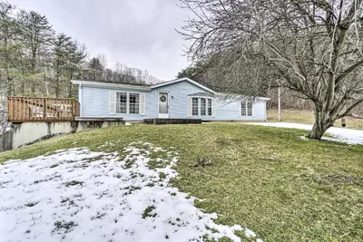 a blue house on a hill with snow on the ground at Rustic Family Home and Acreage about 20 Mi Hocking Hills in Lancaster