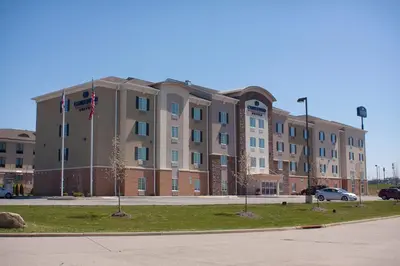a large building with a flag in front of it at Candlewood Suites Youngstown W - I-80 Niles Area by IHG in Austintown