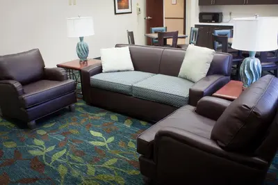 a living room with a couch and two chairs at Candlewood Suites Youngstown W - I-80 Niles Area by IHG in Austintown