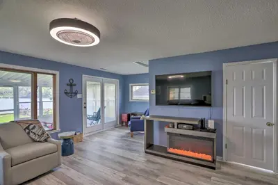 a living room with a couch and a fireplace at Lake Erie Waterfront Home with Sunroom and Yard! in Erie