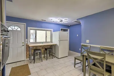 a kitchen with blue walls and a table and a refrigerator at Lake Erie Waterfront Home with Sunroom and Yard! in Erie