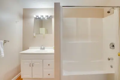 a white bathroom with a sink and a shower at Serene Mountain Retreat on 40 Acres with Fire Pit! in Bomont