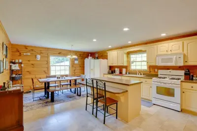 a kitchen with white appliances and a table with chairs at Serene Mountain Retreat on 40 Acres with Fire Pit! in Bomont