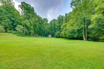 a large field with a shed in the middle of a forest at Serene Mountain Retreat on 40 Acres with Fire Pit! in Bomont