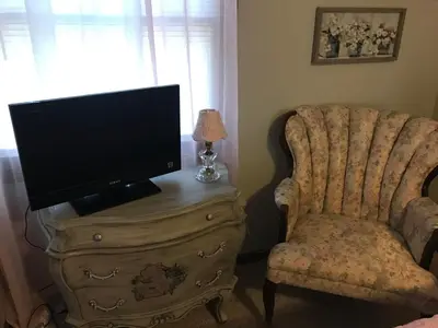 a living room with a tv and a chair at Hope Bed and Breakfast in Canton