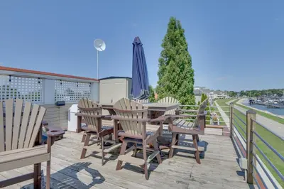 a patio with a table and chairs on a deck at Lakefront Home with Rooftop Deck, Grill, Games! in Hebron