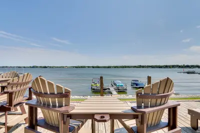 a wooden table and chairs on a dock next to the water at Lakefront Home with Rooftop Deck, Grill, Games! in Hebron