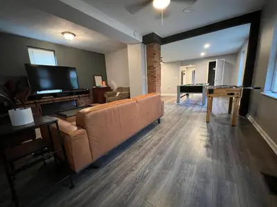 a living room with a couch and a pool table at **Stylish Pet Friendly 3 Bedroom House** in Cleveland