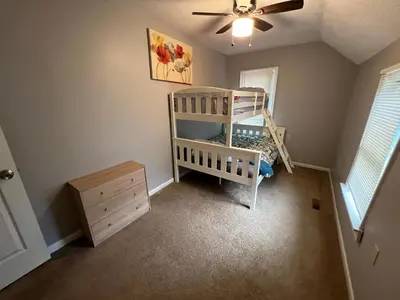 a room with a crib and a dresser in it at **Stylish Pet Friendly 3 Bedroom House** in Cleveland