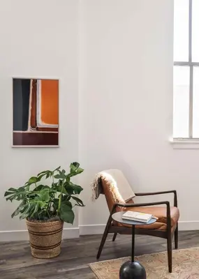 a living room with a chair and a plant at ROOST Cleveland in Cleveland