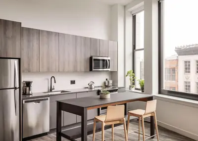 a kitchen with a table and chairs and a refrigerator at ROOST Cleveland in Cleveland