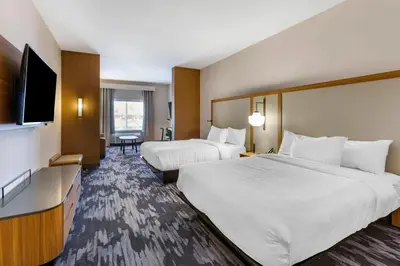 a hotel room with two beds and a flat screen tv at Fairfield by Marriott Inn & Suites Sandusky in Sandusky