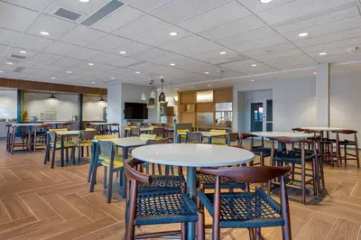 a dining area with tables and chairs in a cafeteria at Fairfield by Marriott Inn & Suites Sandusky in Sandusky