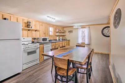 a kitchen with a wooden table and a white refrigerator at Take 5 Retreat with Hot Tub Relax, Rest, Refresh! in Somerset
