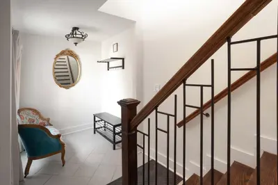 a staircase with a chair and a mirror at Gather Together - Charming Home for 20 Near Ark! in Williamstown