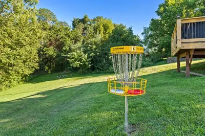a yellow frisbee golf basket in the grass at Gather Together - Charming Home for 20 Near Ark! in Williamstown