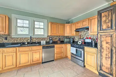 a kitchen with wooden cabinets and stainless steel appliances at Pet-Friendly Covington Retreat with Fenced Yard in Covington