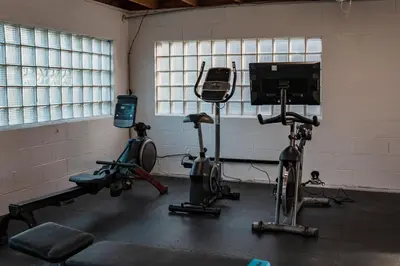 a gym with three exercise bikes and a tv at Sandusky Bay Hot Tub, Gym, Patio, Games, Recreation Watercraft, Waterside Home, check it out! in Port Clinton