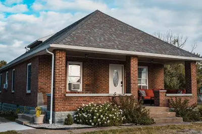 a small brick house with a porch and a window at Sandusky Bay Hot Tub, Gym, Patio, Games, Recreation Watercraft, Waterside Home, check it out! in Port Clinton