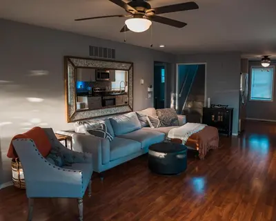 a living room with a blue couch and a mirror at Sandusky Bay Hot Tub, Gym, Patio, Games, Recreation Watercraft, Waterside Home, check it out! in Port Clinton