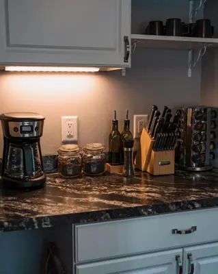a kitchen counter with a coffee maker and bottles of wine at Sandusky Bay Hot Tub, Gym, Patio, Games, Recreation Watercraft, Waterside Home, check it out! in Port Clinton