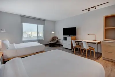 a hotel room with two beds and a desk and a television at TownePlace Suites by Marriott Cincinnati Airport South in Florence