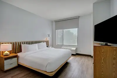 a bedroom with a large bed and a flat screen tv at TownePlace Suites by Marriott Cincinnati Airport South in Florence