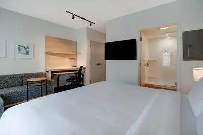 a hotel room with a large white bed and a desk at TownePlace Suites by Marriott Cincinnati Airport South in Florence