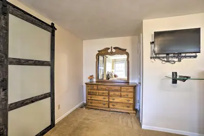 a bedroom with a mirror and a dresser with a dresser at Delightful Tipp City Unit with Covered Patio! in Tipp City