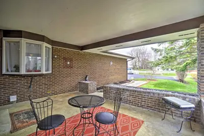 a patio with a table and chairs and a brick wall at Delightful Tipp City Unit with Covered Patio! in Tipp City