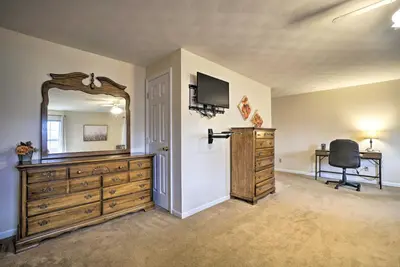 a bedroom with a dresser and a mirror and a chair at Delightful Tipp City Unit with Covered Patio! in Tipp City