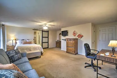 a bedroom with a bed and a couch and a table at Delightful Tipp City Unit with Covered Patio! in Tipp City