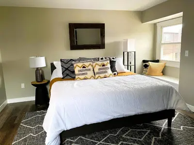 a bedroom with a bed with pillows and a mirror at Harborview 3-6-8 on Main in Huron