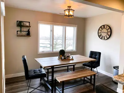 a dining room with a wooden table and chairs at Harborview 3-6-8 on Main in Huron