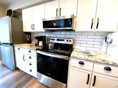 a kitchen with a black stove and a microwave at Harborview 3-6-8 on Main in Huron