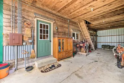 a barn with a green door and a wooden wall at Renovated Bunkhouse on 12-Acre Horse Farm! in Perrysville