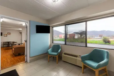 a waiting room with two chairs and a window at Super 8 by Wyndham Charleston WV in Charleston