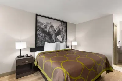a hotel room with a bed with a yellow and black bedspread at Super 8 by Wyndham Charleston WV in Charleston