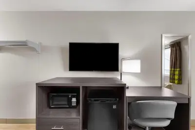 a room with a desk with a tv and a chair at Super 8 by Wyndham Charleston WV in Charleston