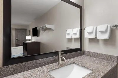 a bathroom with a sink and a large mirror at Super 8 by Wyndham Charleston WV in Charleston