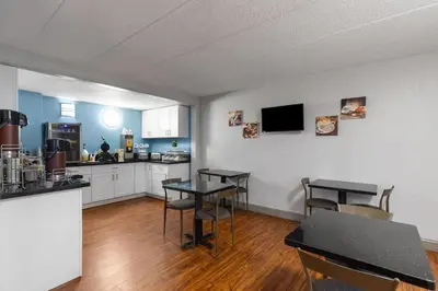 a kitchen with tables and chairs in a room at Super 8 by Wyndham Charleston WV in Charleston